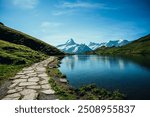 Stone pathway beside swiss alpine lake with mountains in distance