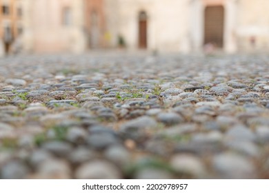 Stone Pavement In Perspective. Old Street Paved With Stone Blocks With White Lines. Shallow Depth Of Field. Vintage Grunge Texture. City ​​and People On Background.