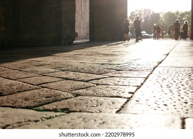 Stone Pavement In Perspective. Old Street Paved With Stone Blocks With White Lines. Shallow Depth Of Field. Vintage Grunge Texture. City ​​and People On Background.