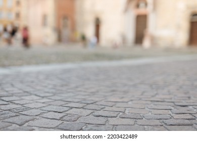 Stone Pavement In Perspective. Old Street Paved With Stone Blocks With White Lines. Shallow Depth Of Field. Vintage Grunge Texture. City ​​and People On Background.