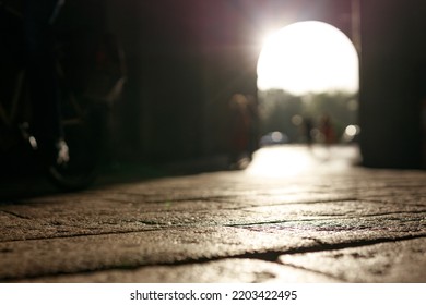 Stone Pavement In Perspective. Old Street Paved With Stone Blocks With White Lines. Shallow Depth Of Field. Vintage Grunge Texture. City ​​and People On Background.