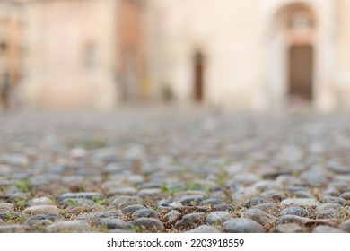 Stone Pavement In Perspective. Old Street Paved With Stone Blocks With White Lines. Shallow Depth Of Field. Vintage Grunge Texture. City ​​and People On Background.