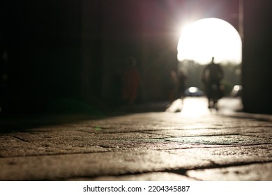 Stone Pavement In Perspective. Old Street Paved With Stone Blocks With White Lines. Shallow Depth Of Field. Vintage Grunge Texture. City ​​and People On Background.