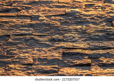 Stone pavement in the rays of the setting sun. Backround of Block pavement on sunset. Texture