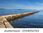 Stone pier at Kardaki Beach inside the Mon Repos estate, on the Kanoni peninsula of Corfu Town, Greece