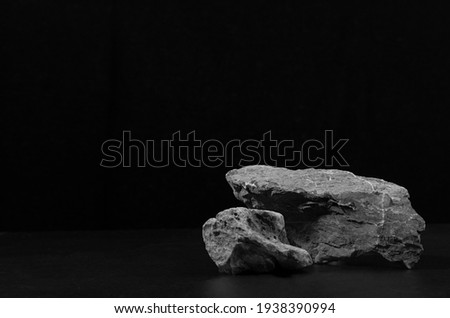 Stone podium for packaging and cosmetic presentation on black background, copy space.