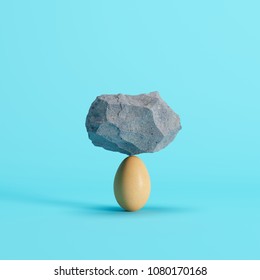 Stone put on Egg on blue background. minimal creative idea concept. - Shutterstock ID 1080170168