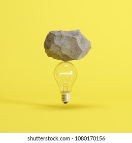 Stone put on  light bulb floating on yellow background. minimal creative idea concept.