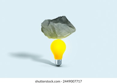 Stone put on yellow light bulb floating on blue background. minimal creative idea concept. Balance, creative idea. Startup, concept