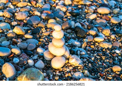 Stone pyramid. Pebbles balance pile, harmony zen stones, balance stack, sea pebble pyramid on shoreline, relaxation and peace concept