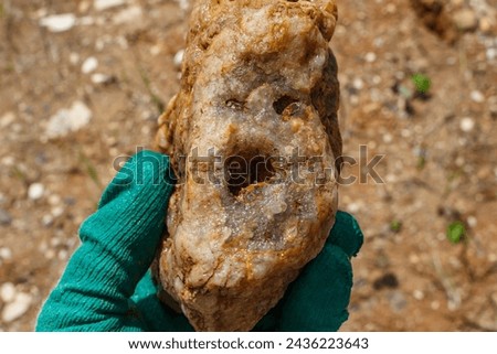 A stone with a quartz geode resembling a face, found during a mineral search