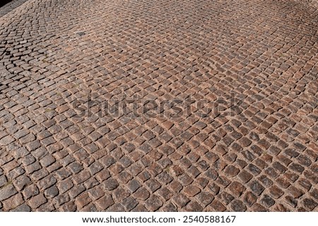 Stone road pattern background. Cobblestone pavement background. Textured background of cobblestone road. Brick road background.