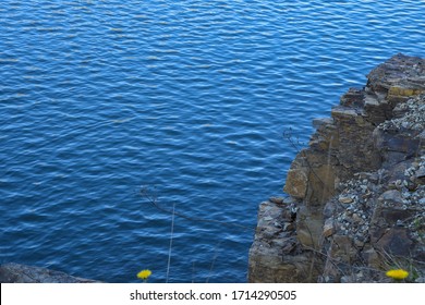 Stone rocks near water, on the background of lake, river, sea, ocean. Blue clear water. Artificial water reservoirs.