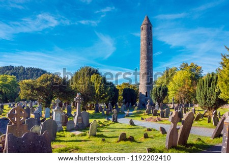 Stone round tower and some ruins of a monastic settlement originally built in the 6th century in Glendalough valley, County Wicklow, Ireland