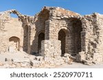 Stone ruins of ancient buildings on the Acropolis of Lindos, Greece. These historic remnants offer a glimpse into the architectural legacy of the ancient Greek civilization.