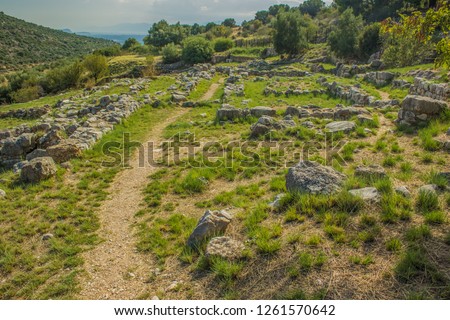 stone ruins of ancient destroyed antique city in Peloponnese area in Greece, tourist and sightseeing concept, nature green landscape environment of world heritage site