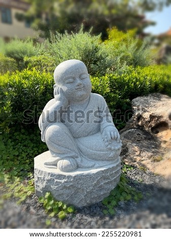 Stone sculpture of  a cute  zen little monk in the garden