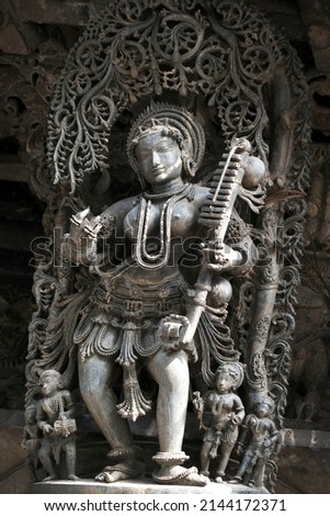 Stone Sculpture of Female (Madanikas) Musician  with selective focus, 12th century Hindu temple, Ancient stone art and sculptures in each pillars, Chennakeshava Temple, Belur, Karnataka, India.