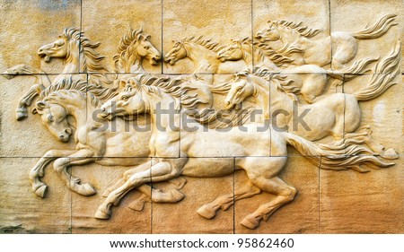 Stone sculpture of horse on wall