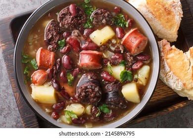 Stone Soup Of Red Beans, Potatoes, Chorizo, Black Pudding Close-up In A Bowl On A Wooden Tray. Horizontal Top View From Above
