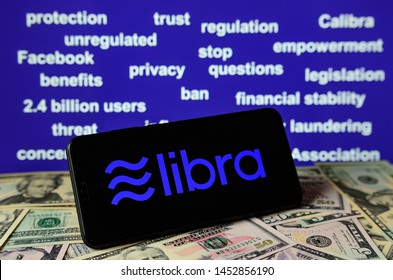 Stone, Staffordshire /UK - July 16 2019:  Smartphone With Libra Logo Placed On Dollar Bills. And A Background Filled With Keywords Form Senate Banking Committee Hearing On Facebook's Libra Currency.