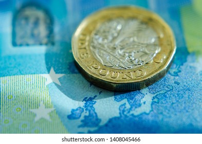 Stone, Staffordshire / United Kingdom -May 26, 2019: Brexit vs British pound. The close up photo of the Pound coin laying on the Euro banknote.