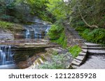 A stone stair follows a series of cascades.  Summer within the gorge of Buttermilk Falls Park.