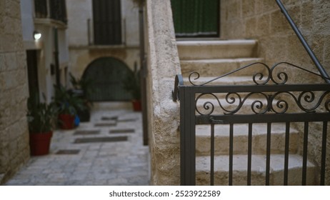 A stone staircase in an old european courtyard with plants in pots and ornamental wrought iron gate, conveying a rustic peaceful atmosphere. - Powered by Shutterstock