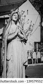 Stone Statue Of A Praying Nun.