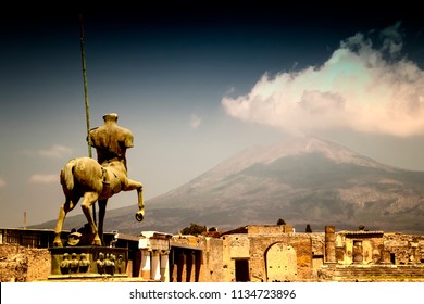 The Stone Statue Of The Roman Hero In The Middle Of Pompei. Behind It Is A View Of The Volcano Vesuvius. It Is Situated In Historical Area In Italy In Europe.