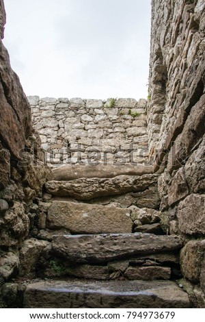 Stone steps down to the crypt in Capel Lligwy, a ruined chapel near Rhos Lligwy in Anglesey, north Wales