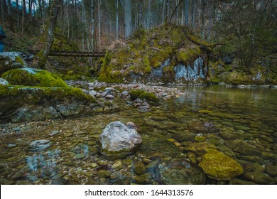 Stone structure at the river spring of Kamniska Bistrica in Slovenia in dry winter time. Cold enchanted rock with flowing water in the middle of the forest.