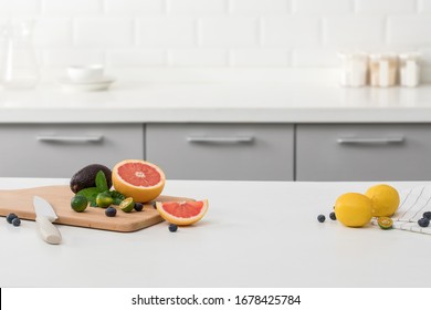 Stone Table Top With Fruits On Blur Kitchen Bench Background.