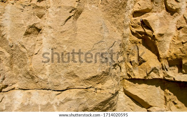 Stone texture and background. Rock
texture. The Enormous face Aging and Divided by Huge Cracks and
Layers. Thick, Rough Stone Texture Or Mountain
Rock.