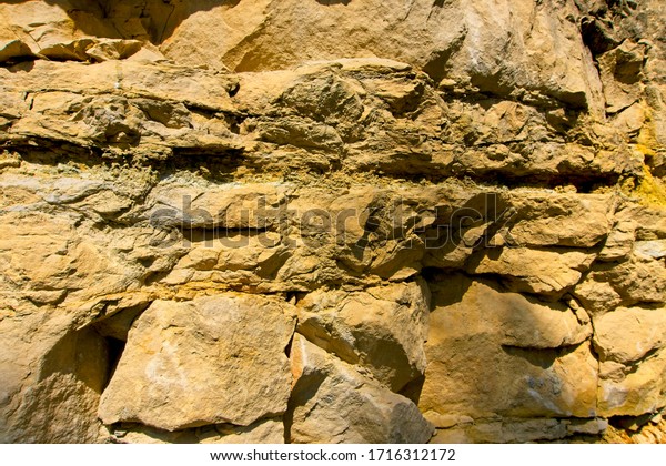 Stone texture and background. Rock\
texture. The Enormous face Aging and Divided by Huge Cracks and\
Layers. Thick, Rough Stone Texture Or Mountain\
Rock.