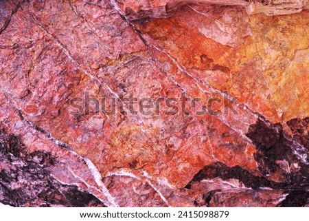 Stone texture background with unique pattern. Pink, red, black rock texture. Rock surface abstract background. Natural stone background. Purple rough stone floor. Grunge and rust rock texture.