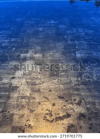 The stone tile at the bottom of the pool is refracted by yellow light