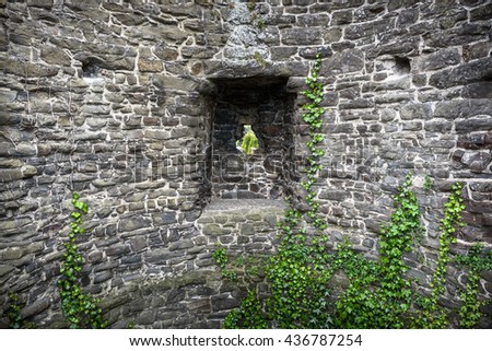 Stone tower of medieval castle with arrowslit