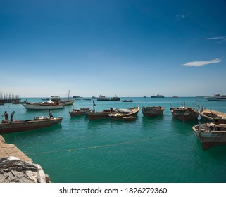 Stone Town, Zanzibar / Tanzania - October 21 2007: Boats And People In The Turquoise Sea At The Harbour