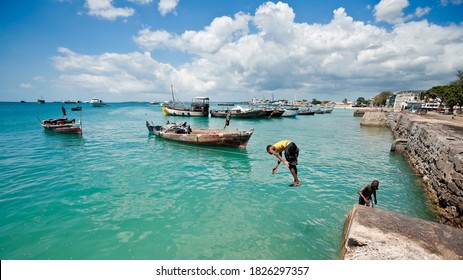 Stone Town, Zanzibar / Tanzania - October 21 2007: Teenagers Jumping In The Turquoise Sea At The Harbour