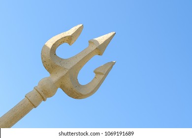 Stone trident against the sky on a summer day