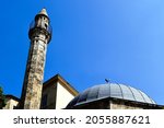 stone Turkish minaret and mosque in Pecs, Hungary. diminishing perspective. low angle view. Islamic architecture. landmark building. named after Jakovari Hassan. blue sky. travel and architecture.