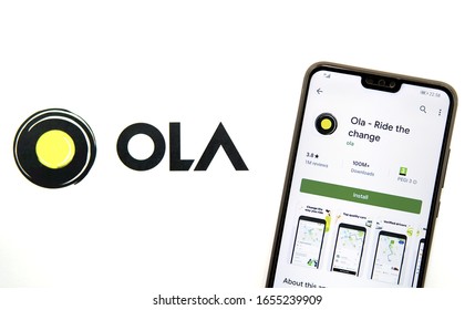 Stone / United Kingdom - February 18 2020: Ola taxi logo projected on the white wall and mobile phone with the Ola app in play market.