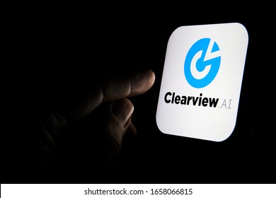 Stone / United Kingdom - February 26 2020: Clearview AI Facial Recognition Software Logo On The Glowing Screen And The Finger Pointing At It. Concept Photo.