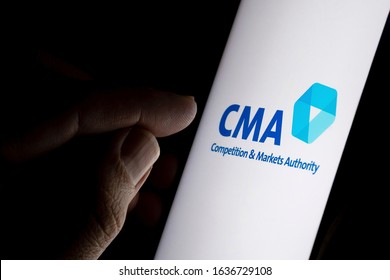 Stone / United Kingdom - February 4 2020: CMA Competition and Markets Authority logo on the screen and finger pointing at it. CMA is a government department also known as British competition watchdog.