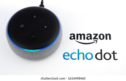 Stone / United Kingdom - January 13 2020: Amazon Echo Dot 3rd generation with blue lights on and device logo printed on paper. Smart speaker with Alexa assistant. Real photo, not a montage. 