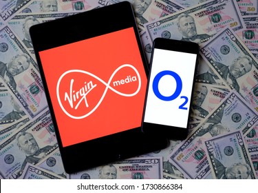 Stone  United Kingdom - May 12 2020: Virgin Media And O2 Telefonica Logos On The Mobile Devices Placed On Dollars. Concept For Potential Multibillion Merger Of The Two Telecom Companies.