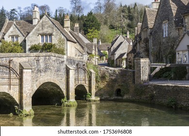 stone village with typical english houses next to a river with a stone bridge, Castle Combe