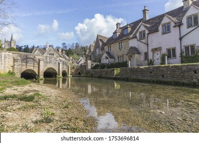 stone village with typical english houses next to a river with a stone bridge, Castle Combe