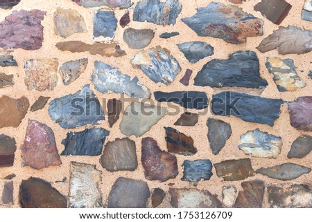 Stone wall background, building feature. Texture of thick and strong wall of rough stones of various shapes and sizes
